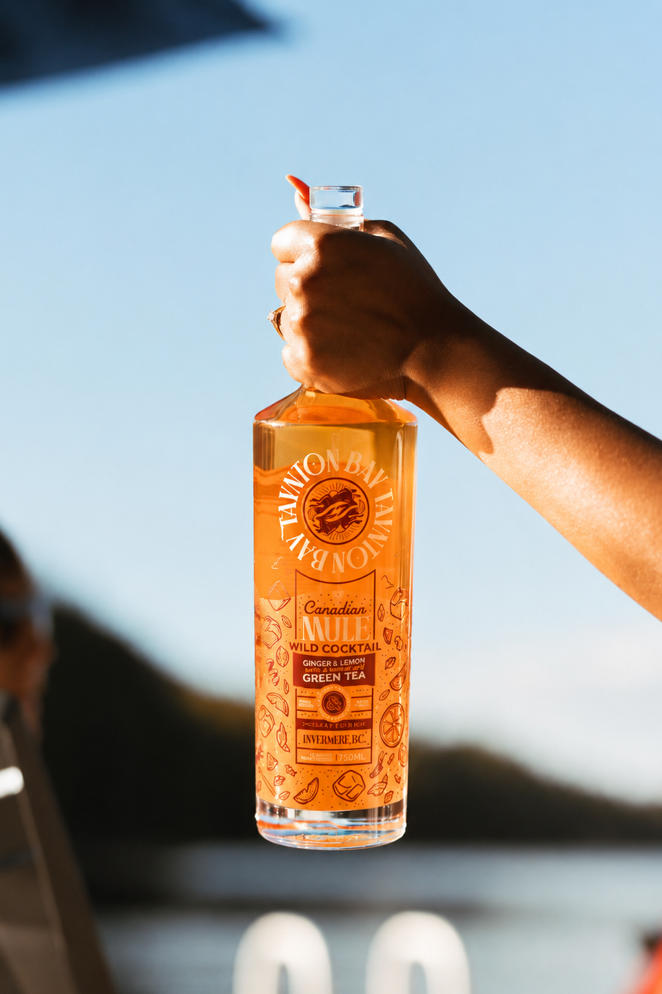 Person holding a bottle of Canadian Mule with a blurred background